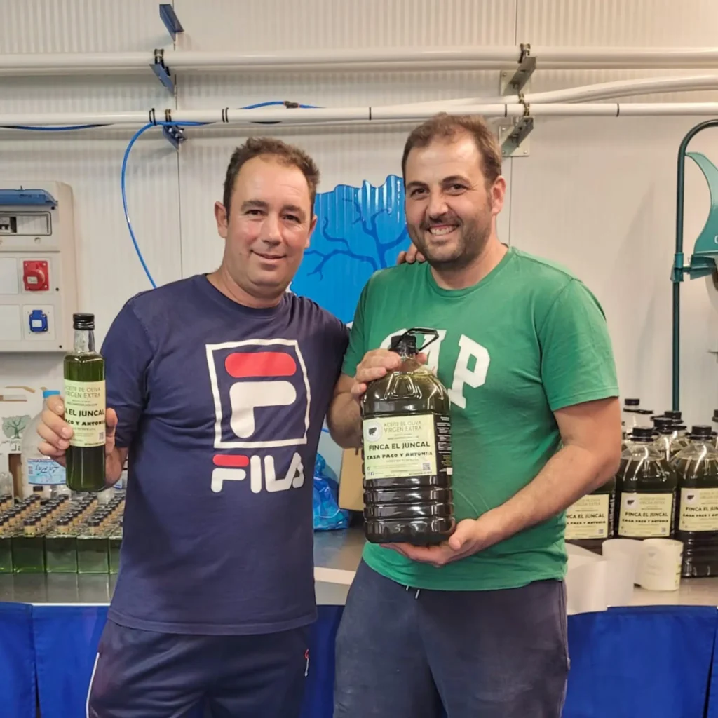 imagen de dos buenos amigos felices y mostrando su aceite embotellado - Campos de Jaén