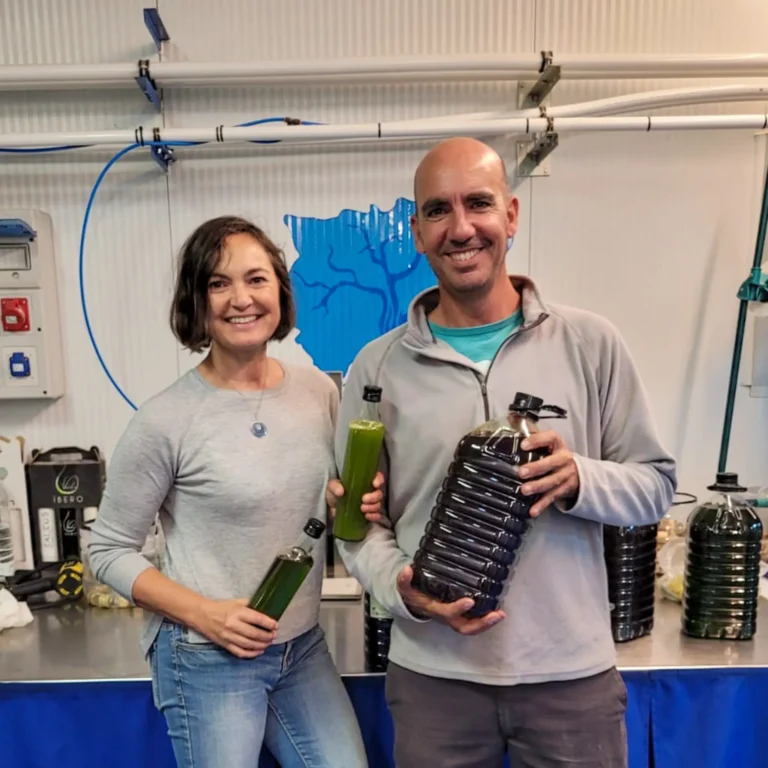 imagen de una pareja de agricultores felices enseñando su aceite embotellado - Campos de Jaén